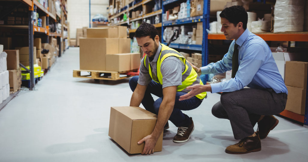 Trainer Helping Worker Lift Properly